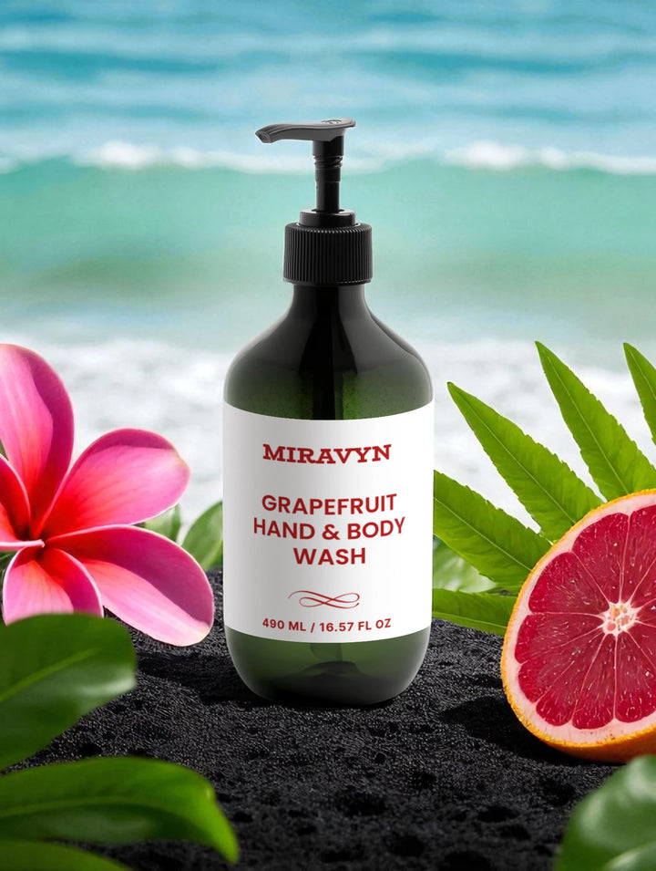 Miravyn Grapefruit Body Wash bottle with tropical flowers and leaves on a beach background.