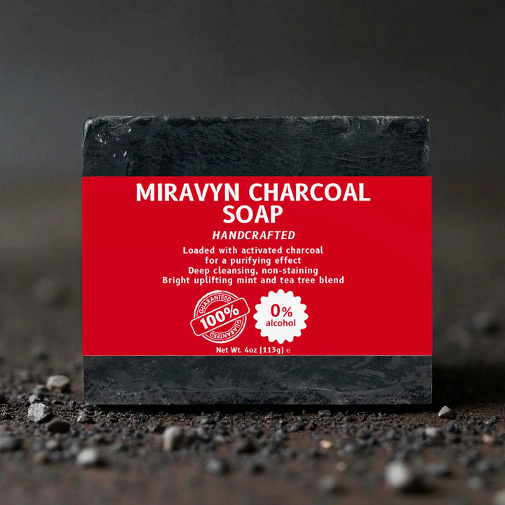 Black bar of Miravyn Charcoal Soap with a red label on a dark charcoal background.