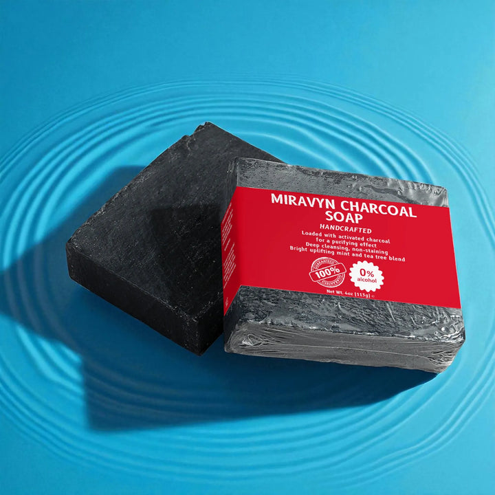 Black charcoal soap bar with a red label on a blue water background.