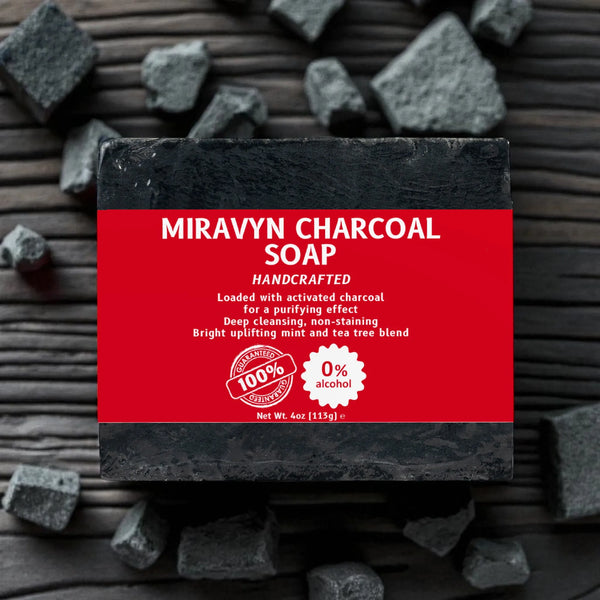 Miravyn Charcoal Soap with red label sitting on charcoal.