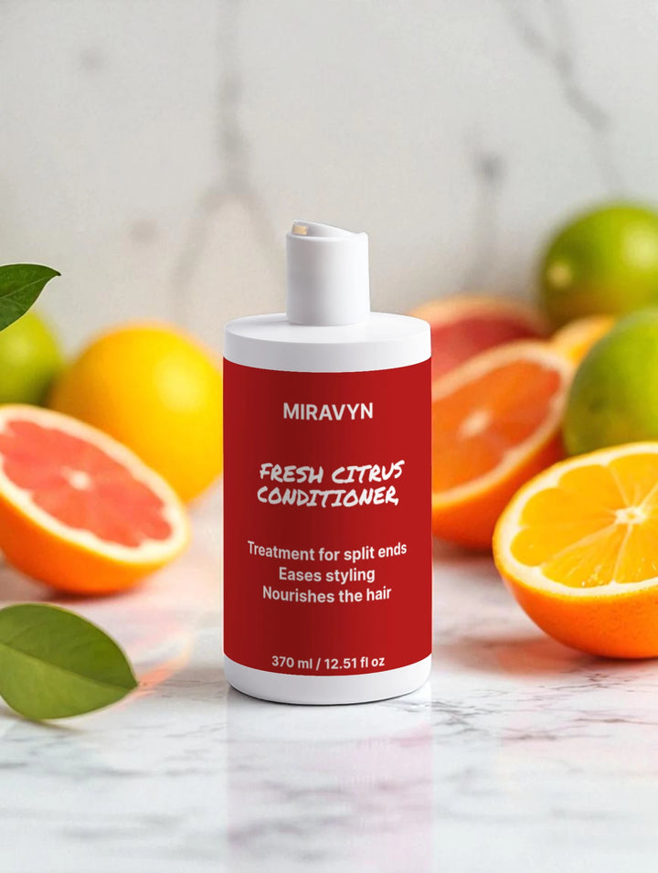 Miravyn Fresh Citrus Conditioner bottle with citrus fruits on a marble surface.