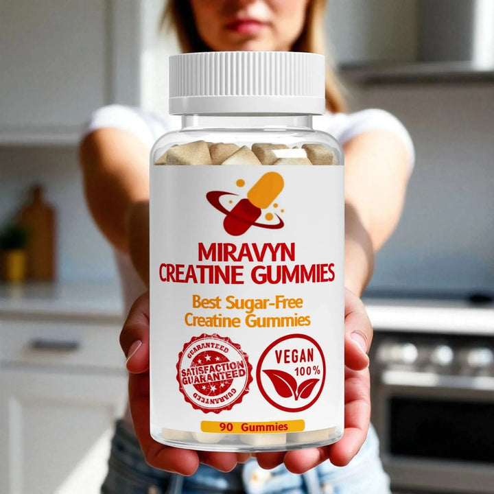 A woman holding a bottle of Miravyn Creatine Gummies in a kitchen setting.