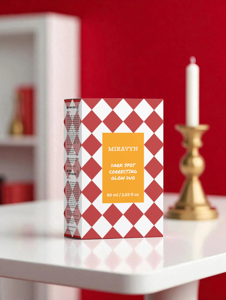 Miravyn dark spot correcting glow serum duo box next to a candle and red background.