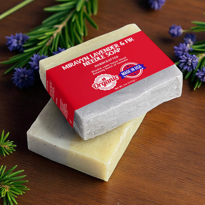 Bar of lavender soap with a red label on a wooden surface with lavender and fir needles.