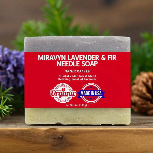 Bar of lavender soap with a red label featuring 'Miravyn' branding, surrounded by lavender and fir needles.