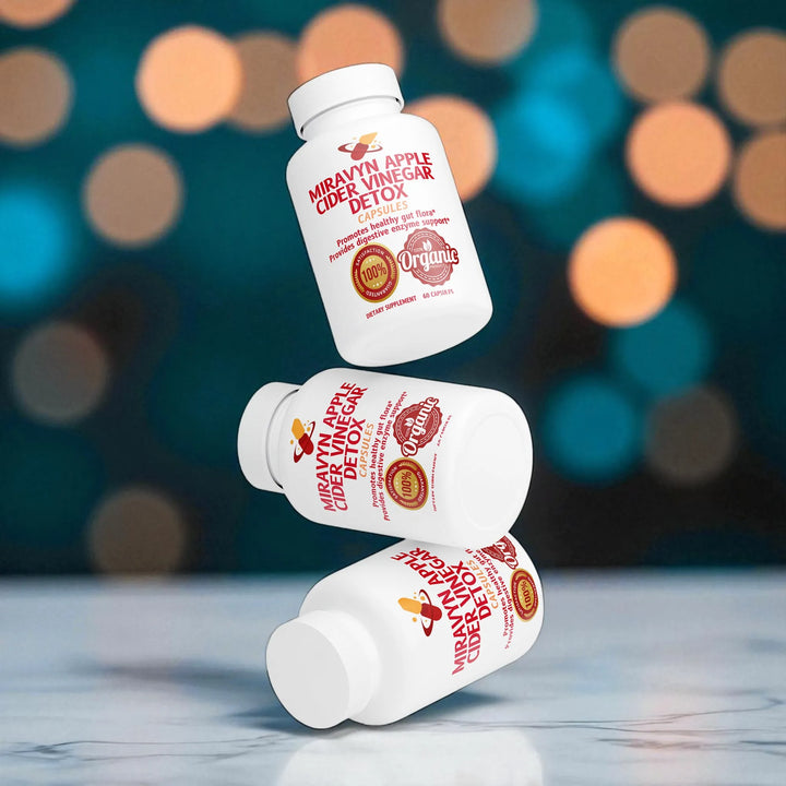 Three bottles of Miravyn Organic Apple Cider Vinegar Detox on a reflective surface with a blurred bokeh effect.