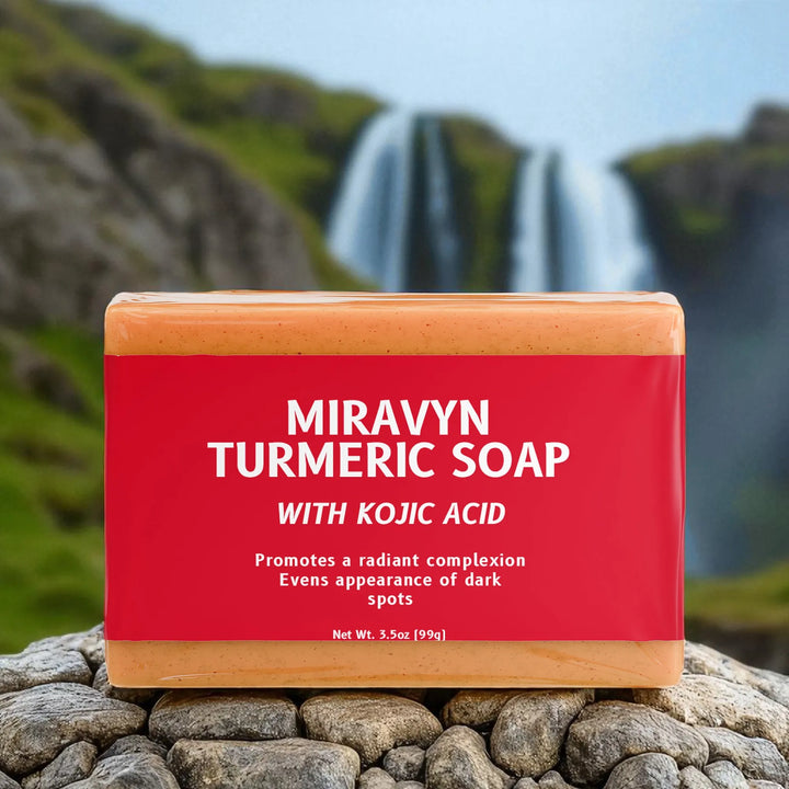 Miravyn Turmeric Soap with Kojic Acid on a rock with a waterfall in the background.