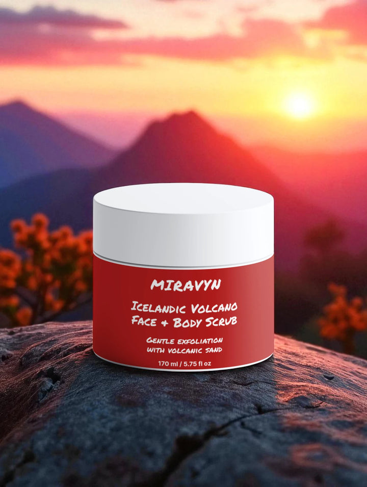 Red jar of Miravyn Volcano Face Exfoliator & Body Scrub on a rock with a mountain sunset background.