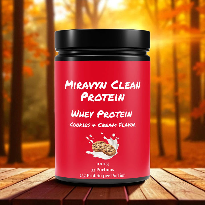 Miravyn whey protein powder cookies & cream container against a blurred autumn forest background.