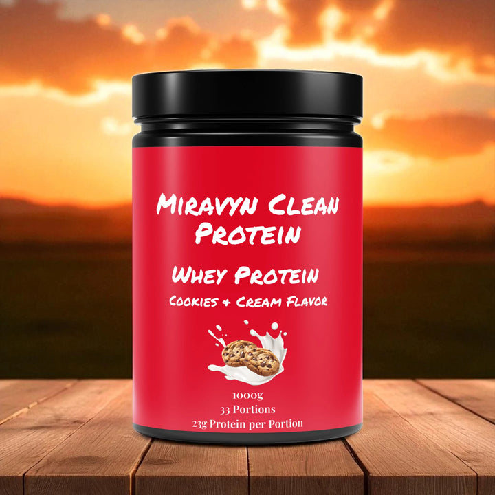 Miravyn whey protein powder cookies & cream container on a wooden surface with a sunset background.