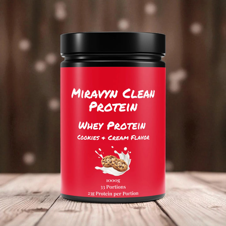 Miravyn whey protein powder cookies & cream container with black lid on a wooden surface.